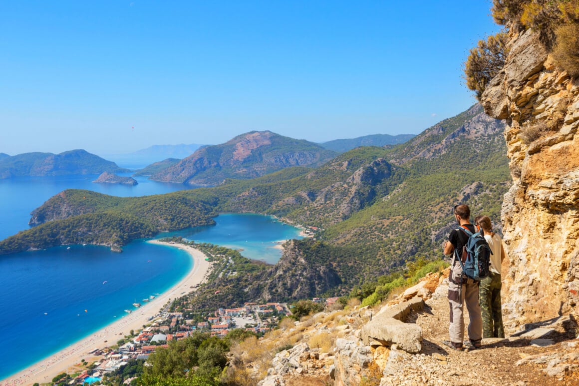 A couple standing on top of a cliff at the Lycian Way, Turkey
