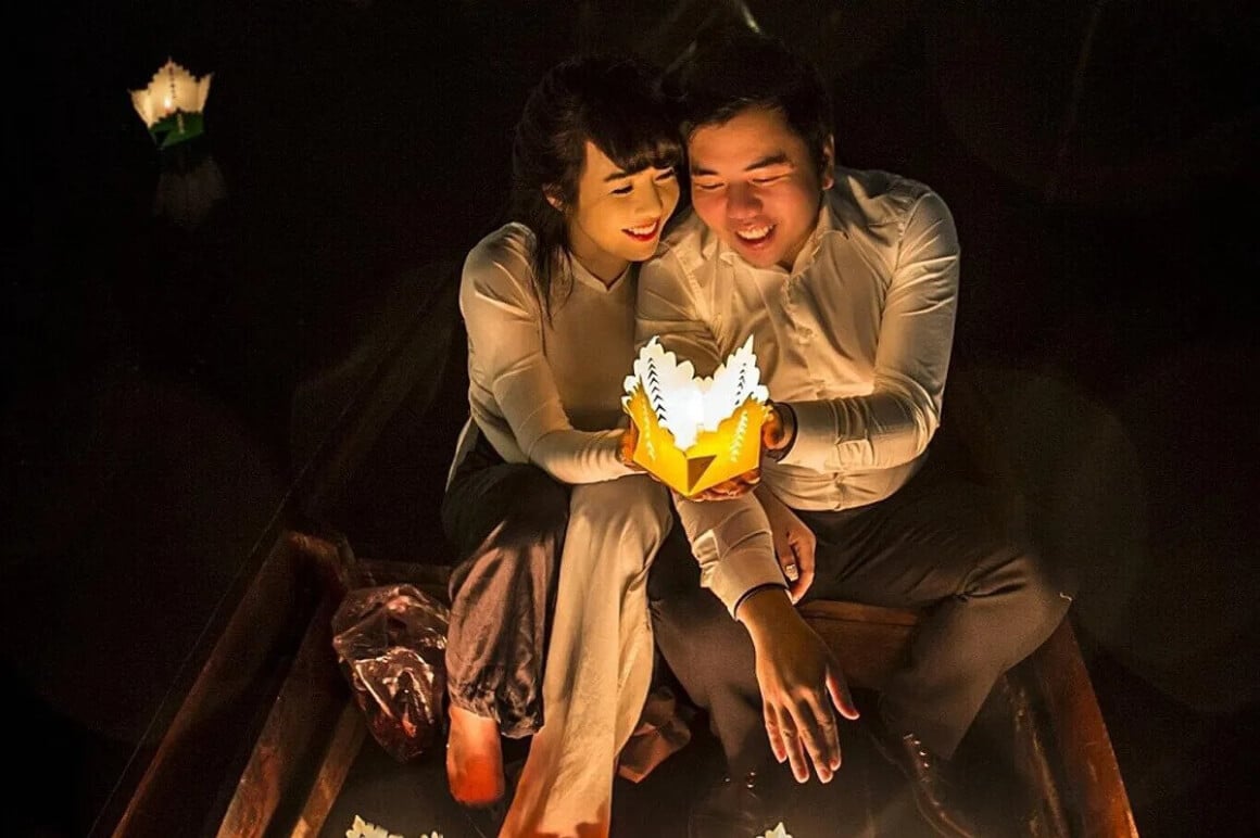 A romantic couple, holding a lantern, enjoying a riverboat tour 