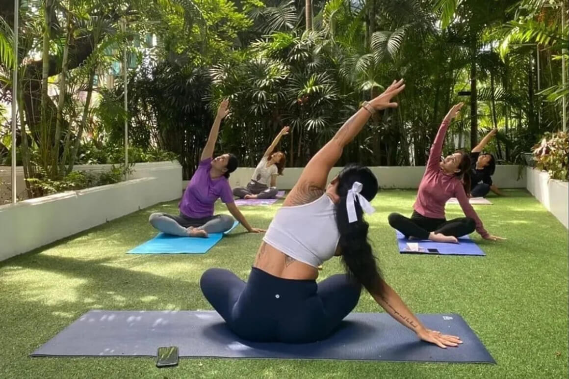 A group of women sitting on their yoga matt engaged in a yoga session 
