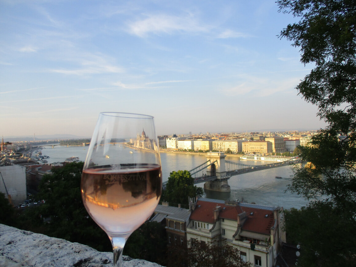 A glass of wine with a view of Budapest in the backdrop