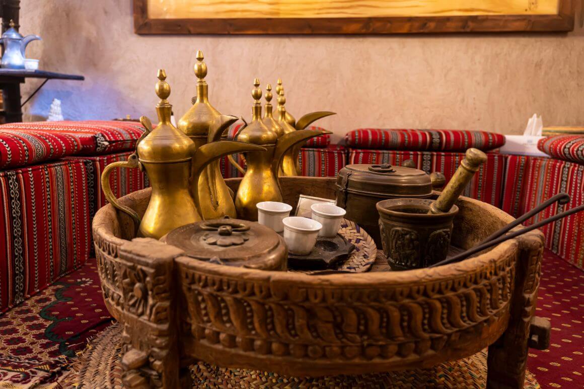 A wooden table with a coffee pots and cups in Dubai Coffee Museum