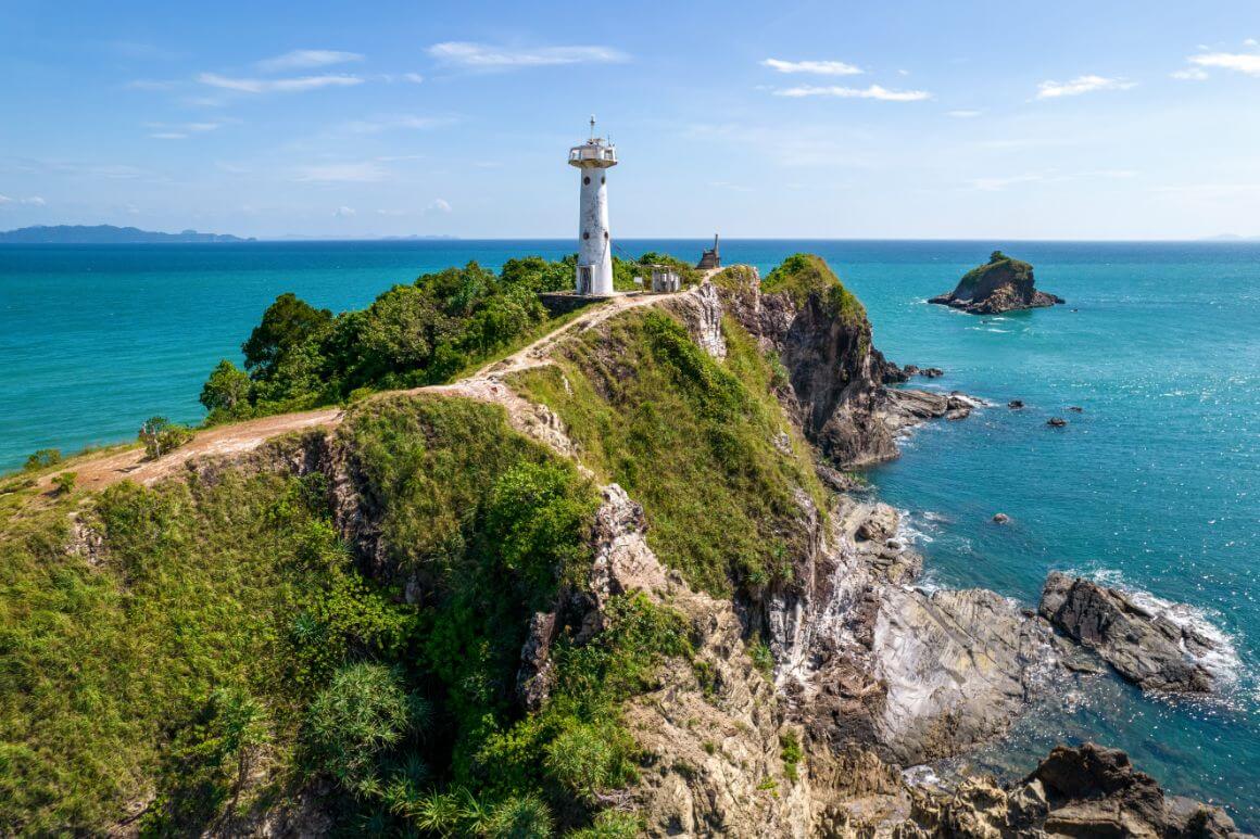 A white lighthouse on a cliff overlooking the ocean in Mu Ko Lanta Park, Thailand