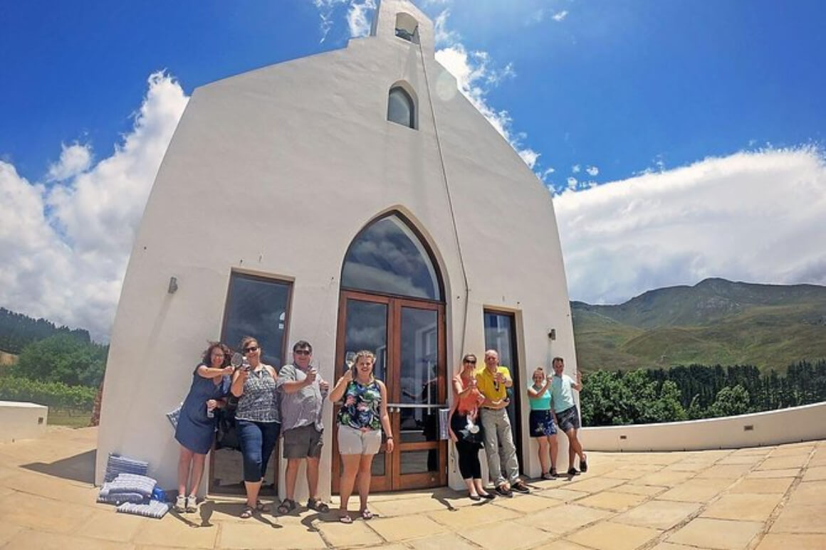 a family standing in front of a white wine cellar on a winery tour in Walker Bay