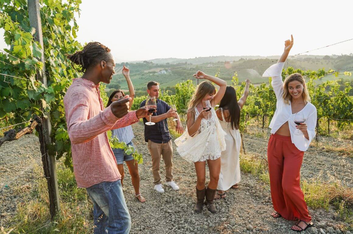 people dancing with glasses of wine in an australian wine vineyard