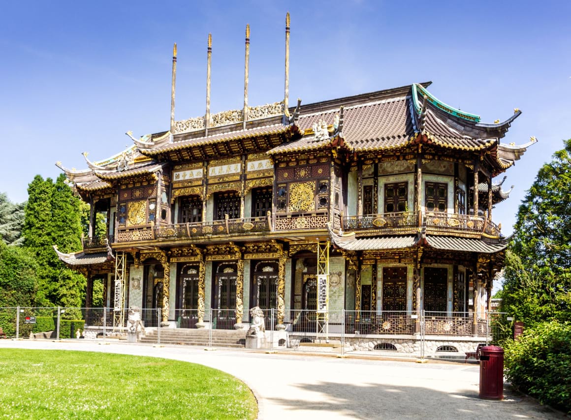 Museum of the Far East with detailed chinese-style architecture surrounded by grass and trees in Brussels