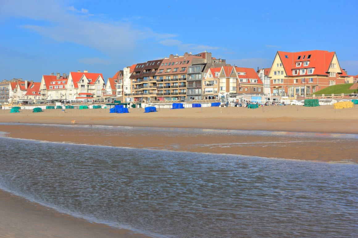 Strand De Haan beach, Belgium, with a row of houses in the background.