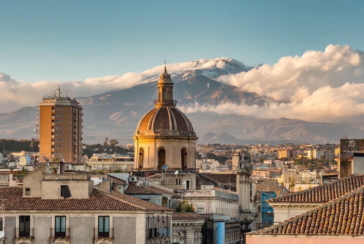 Catania cityscape with the view of Etna volcano at sunset in Sicily, Italy.