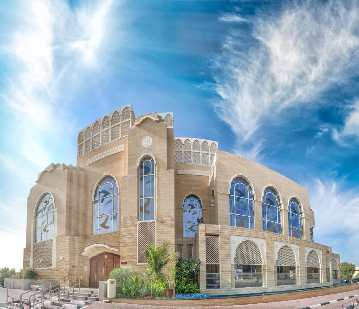 Guru Nanak Darbar Temple in Dubai featuring stunning glassy windows and intricate Arabian-style architecture.