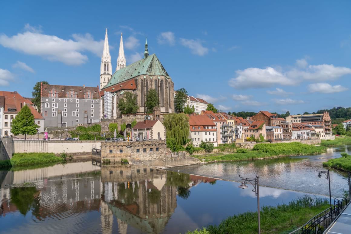 A photo of a church on the river's banks and surrounded by trees in the village Gorlitz