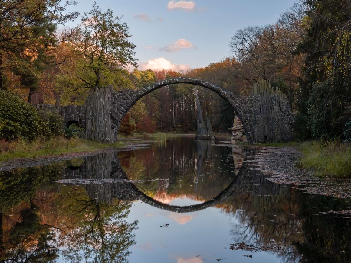 A bridge over a river surrounded by trees in Rakotzbrucke Saxony