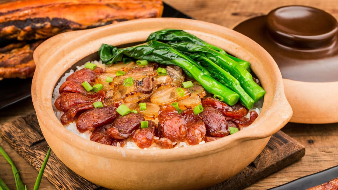a tan pot filled with meat rice and green vegetables in hong kong