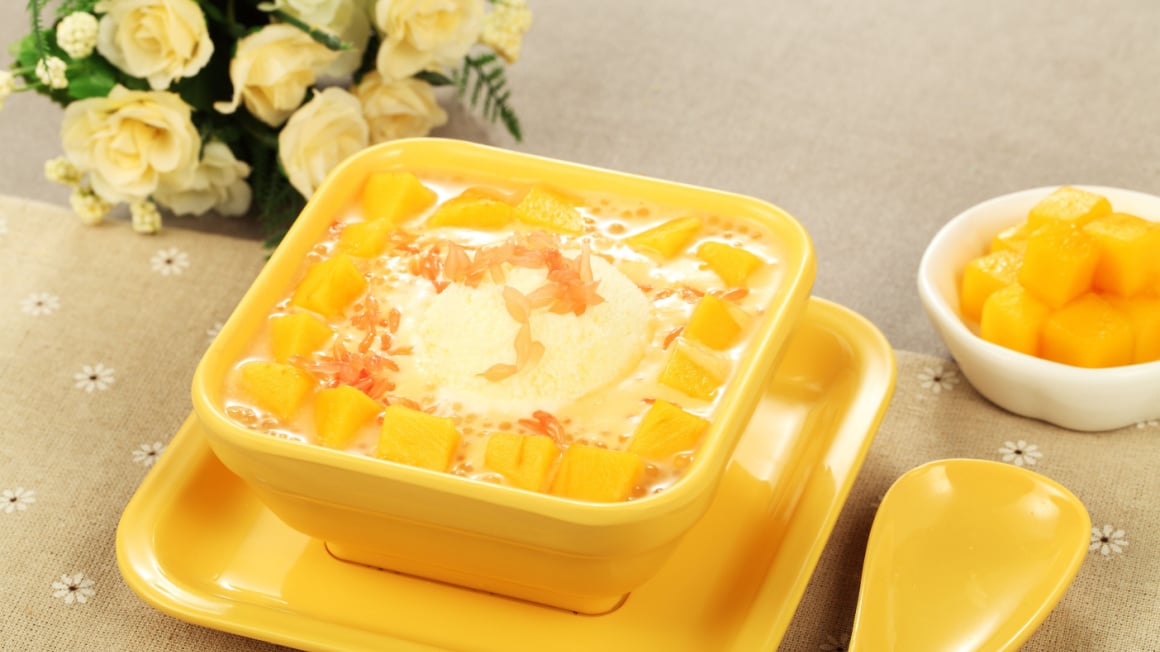 bright yellow mango dessert in a square yellow bowl in hong kong