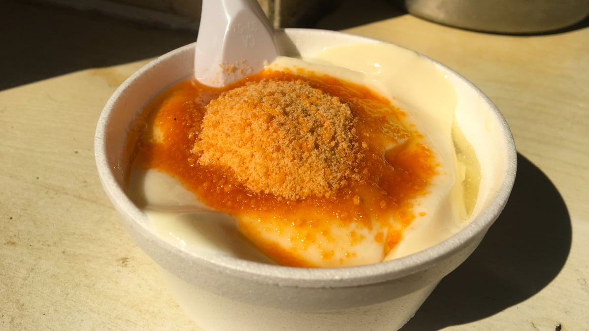 off white pudding topped with caramel sauce in a white cup in hong kong