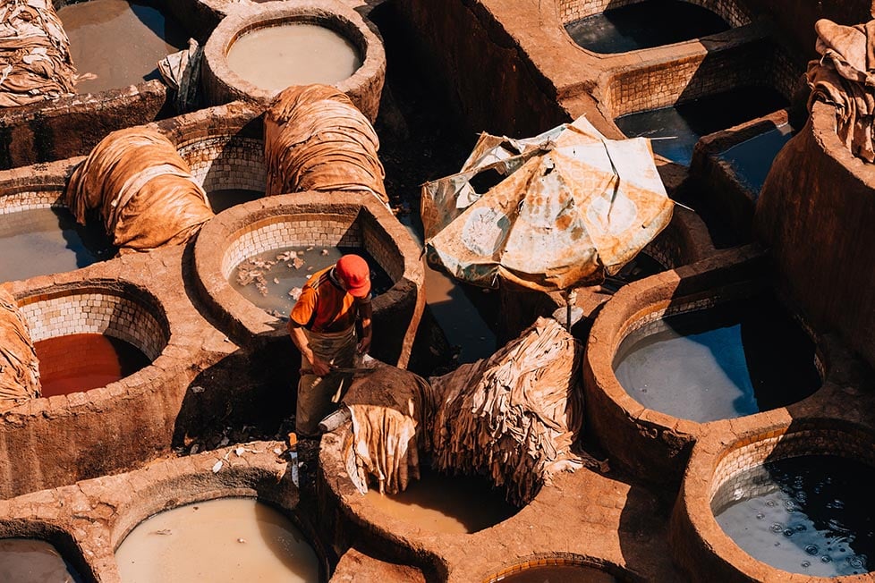 A man working in the pits of a leather tannery in Fes