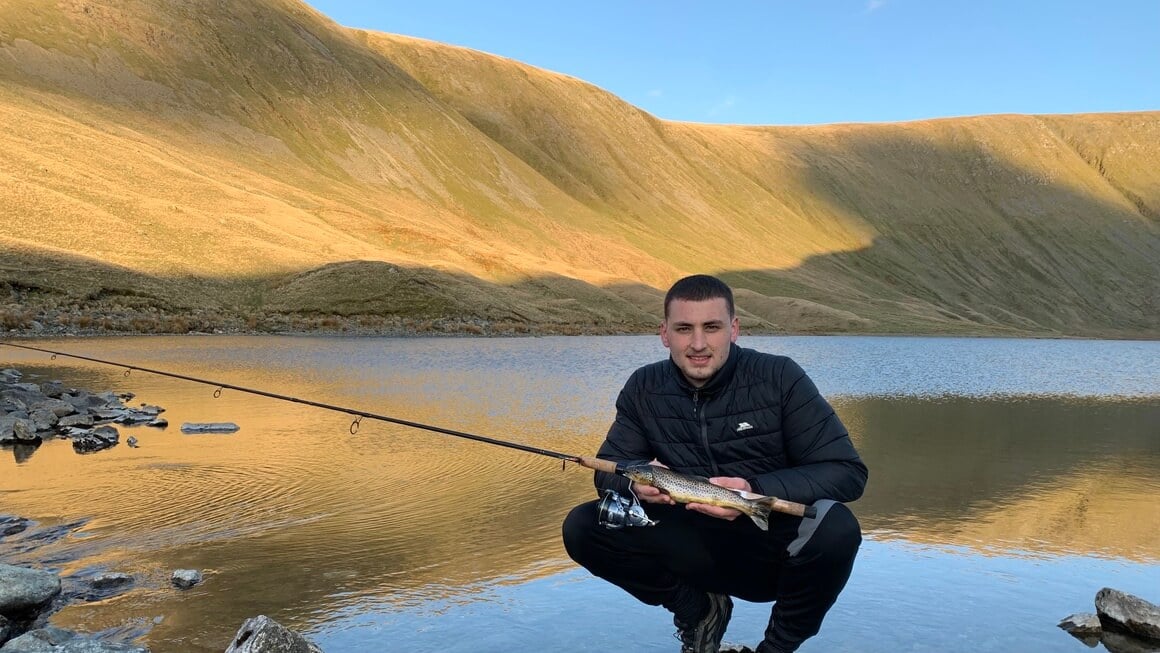 Man with a fish in mountains