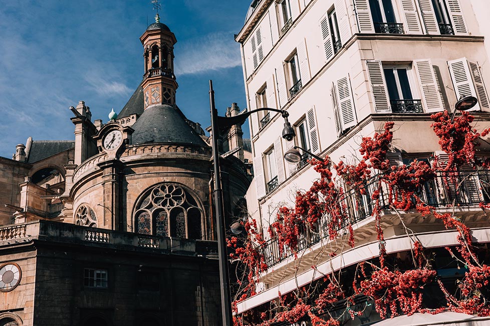 A cafe and church with flowers on the streets of Paris
