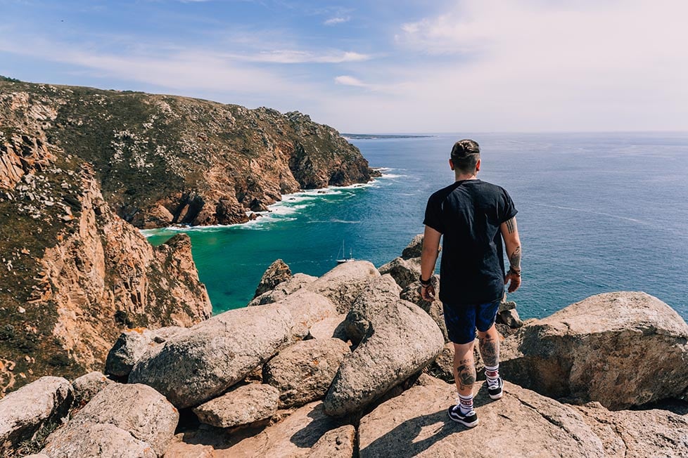 A person looking out over the rocky cliffs of Portugal