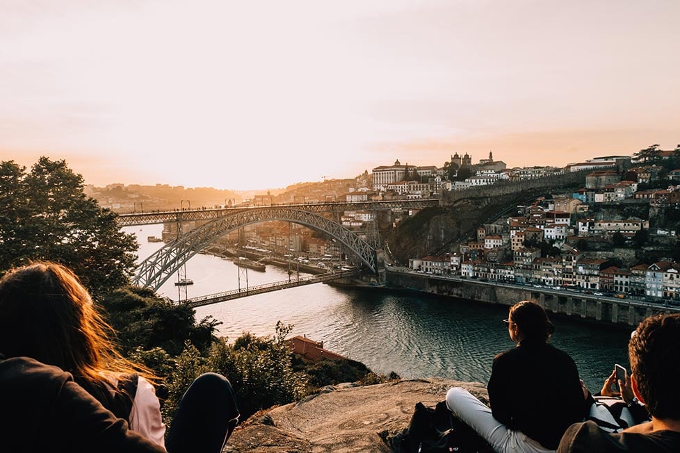 A group of people watch the sunset over Porto, Portugal