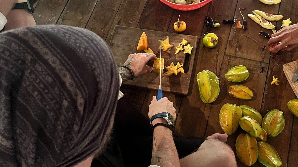 Cutting calambola fruit on a wooden chopping board.