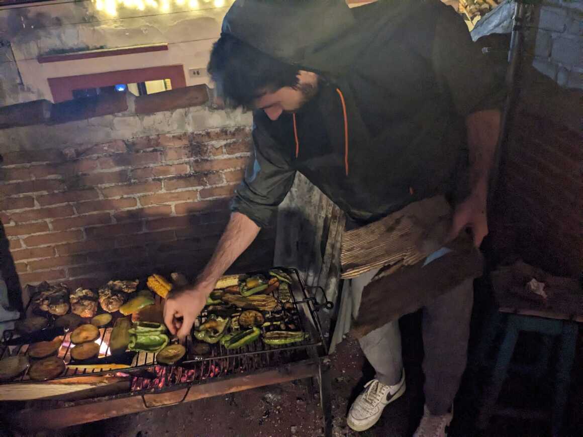 Man cooking food on the grill using his hands.