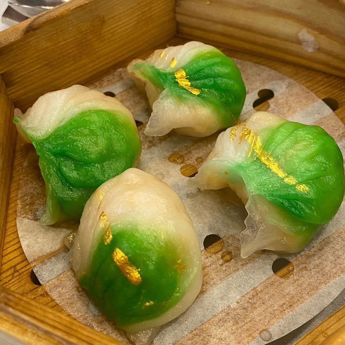 four shrimp dumplings with green and gold coloring