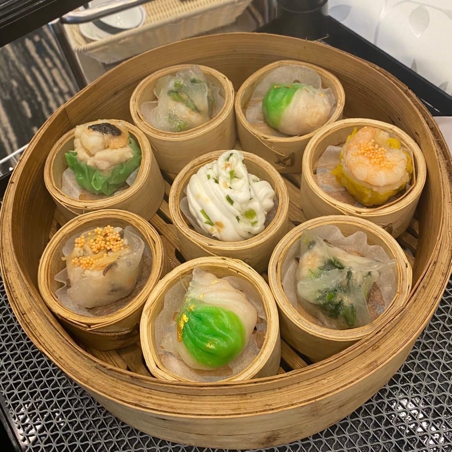 an assortment of hong kong food dim sum dumplings in a wooden bowl
