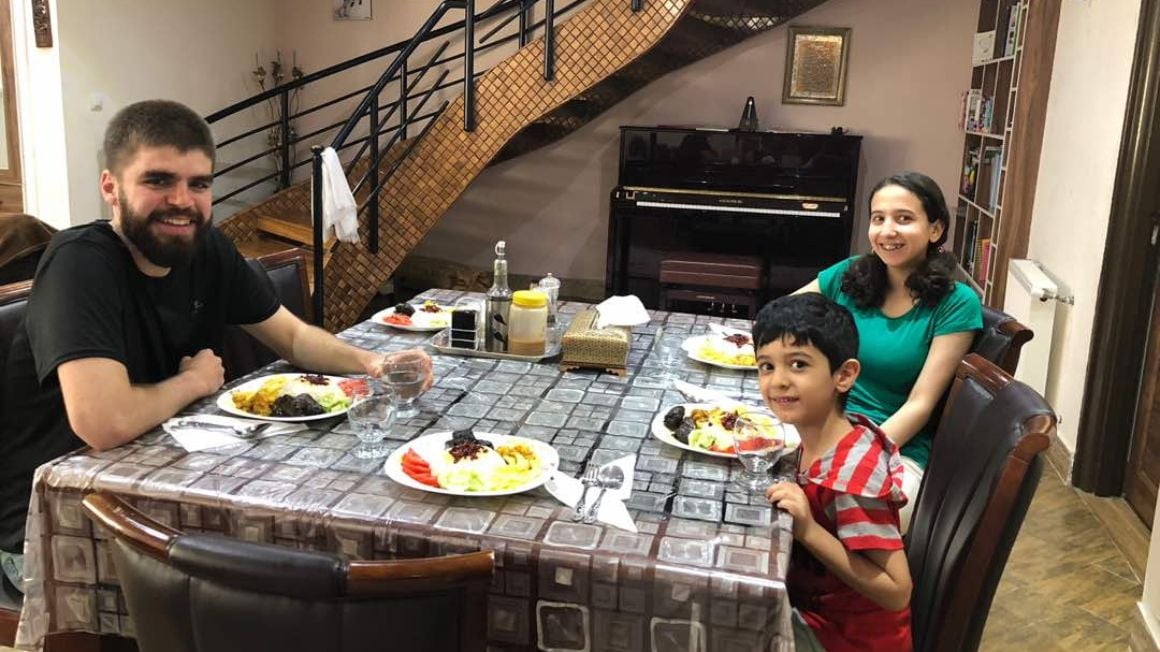 backpacker shares a meal with couchsurfing family in Iran