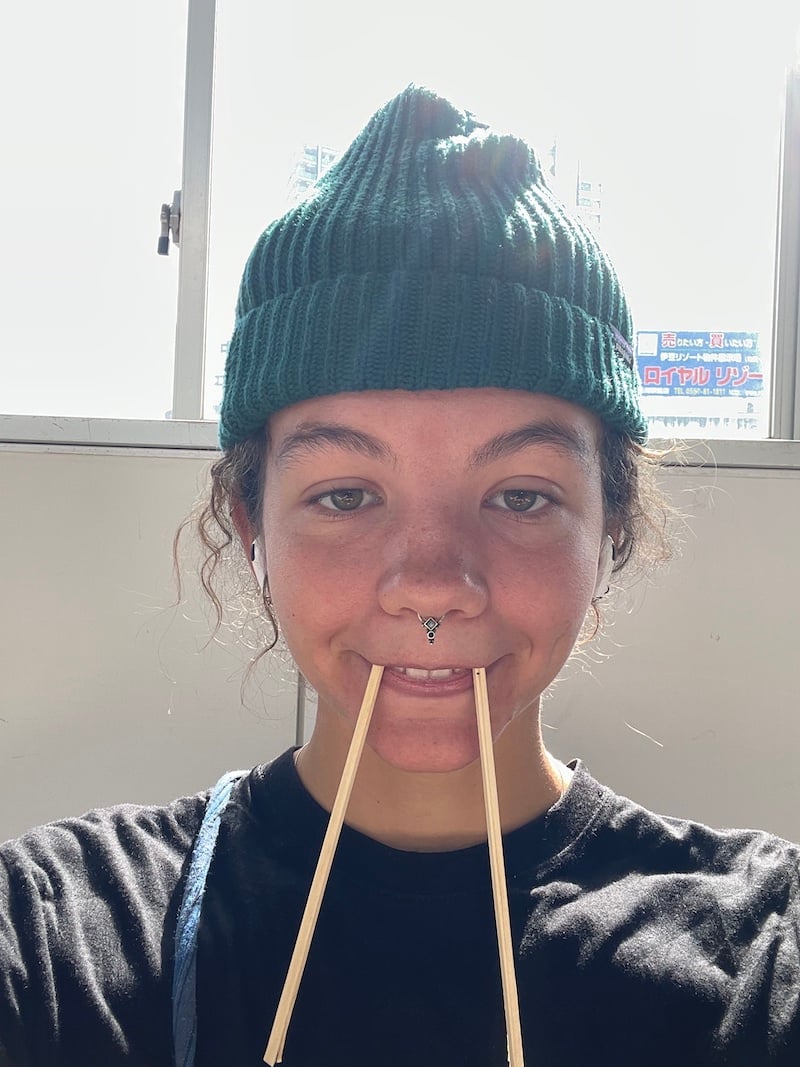Girl takes selfie with chopsticks in her mouth like a walrus.