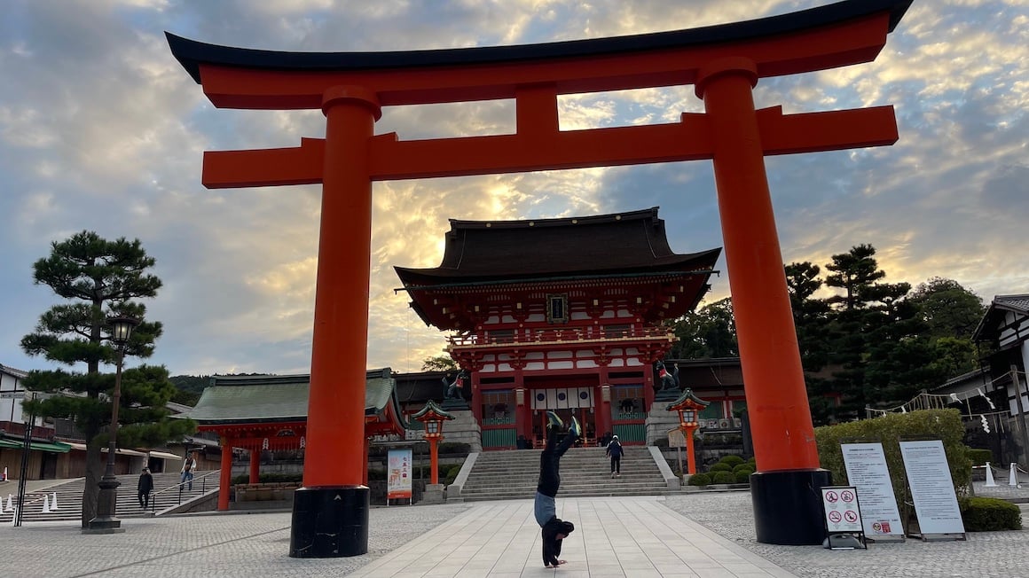 Guy does handstand at entrance to temple in Kyoto, Japan.
