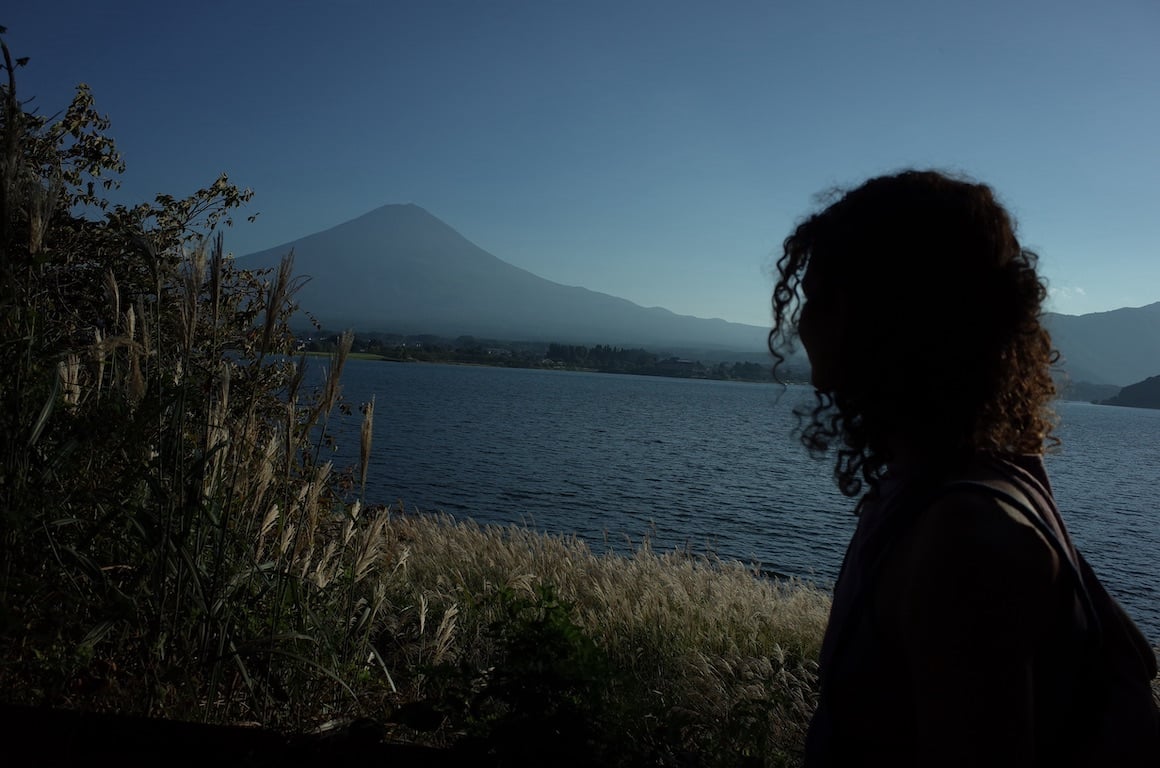 Girl looks over view of Lake Kawaguchiko and Fuji-san in Japan.