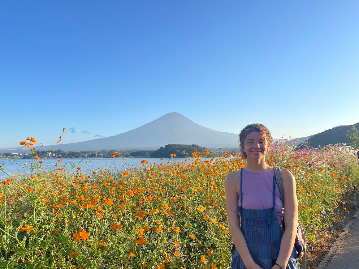 Girl smiles for photo in front of Mt. Fuji Japan on Lake Kawaguchiko.