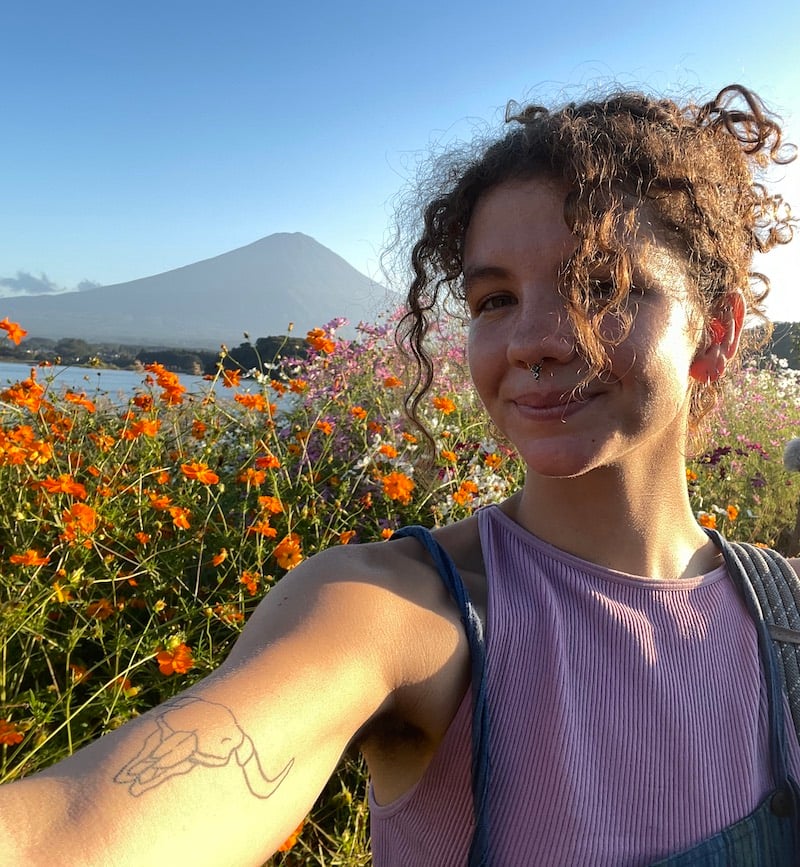 Girl takes selfie in the flower garden of Oishi Park Lake Kawaguchiko, Japan.