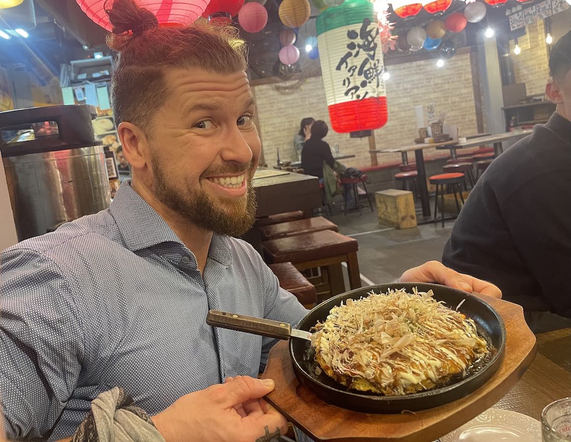 Eating Okonomiyaki in Osaka Japan on a street food tour.
