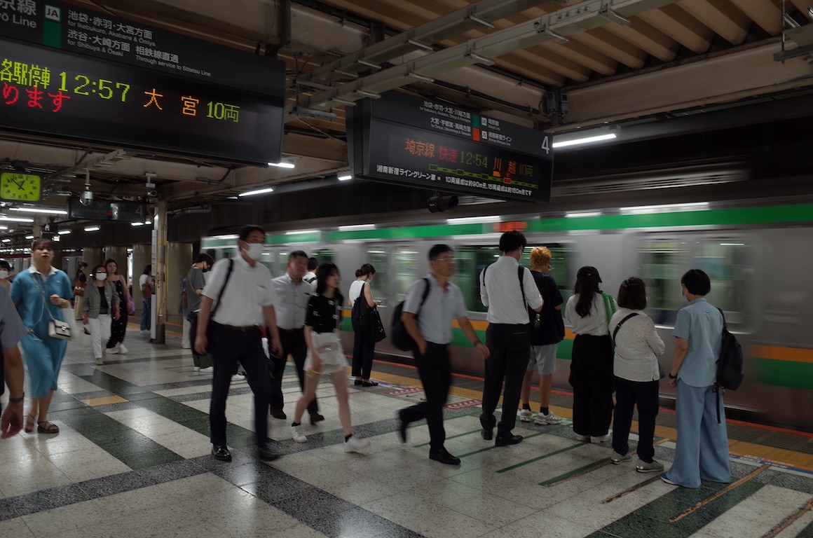 Japanese crowded subway station as a train passes by.