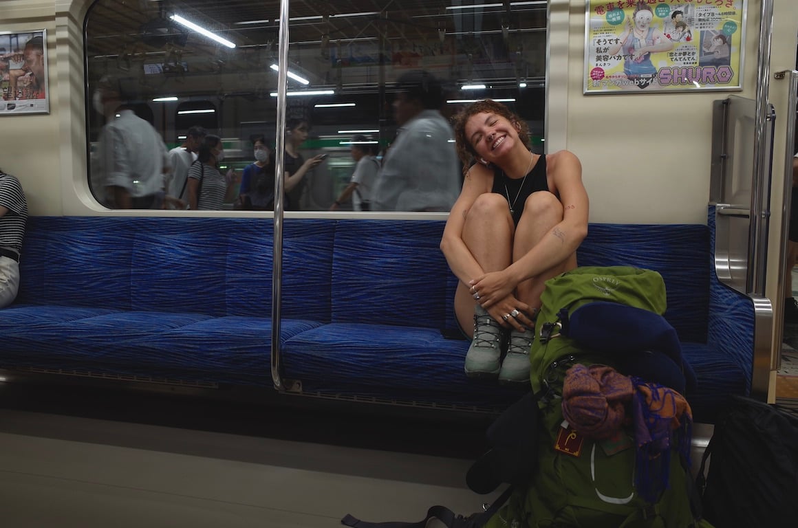 Smiling girl riding a train in Japan.