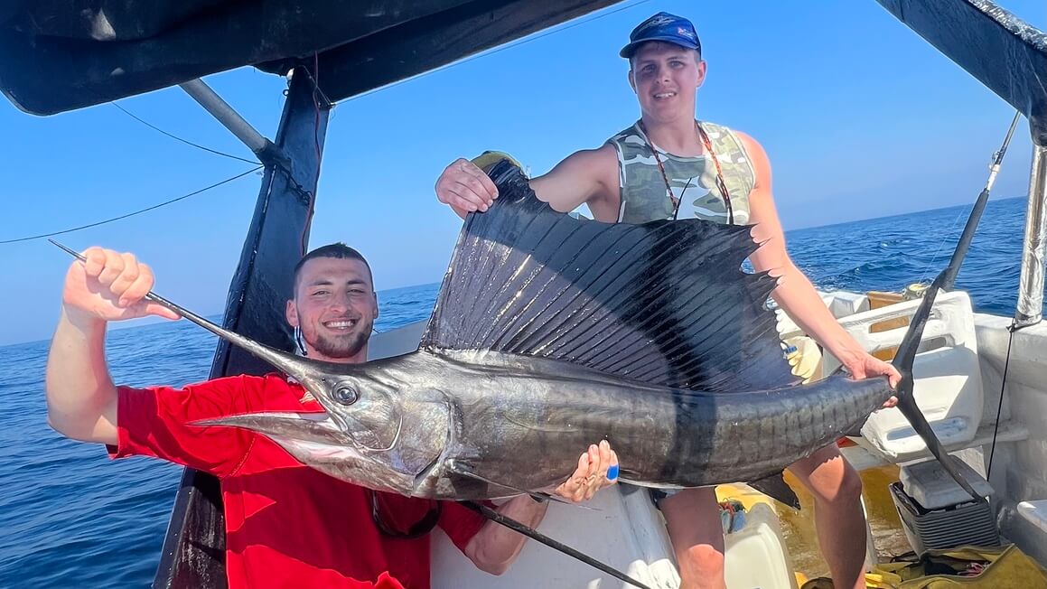 Posing with the catch of the day, a big sailfish caught in Mexico