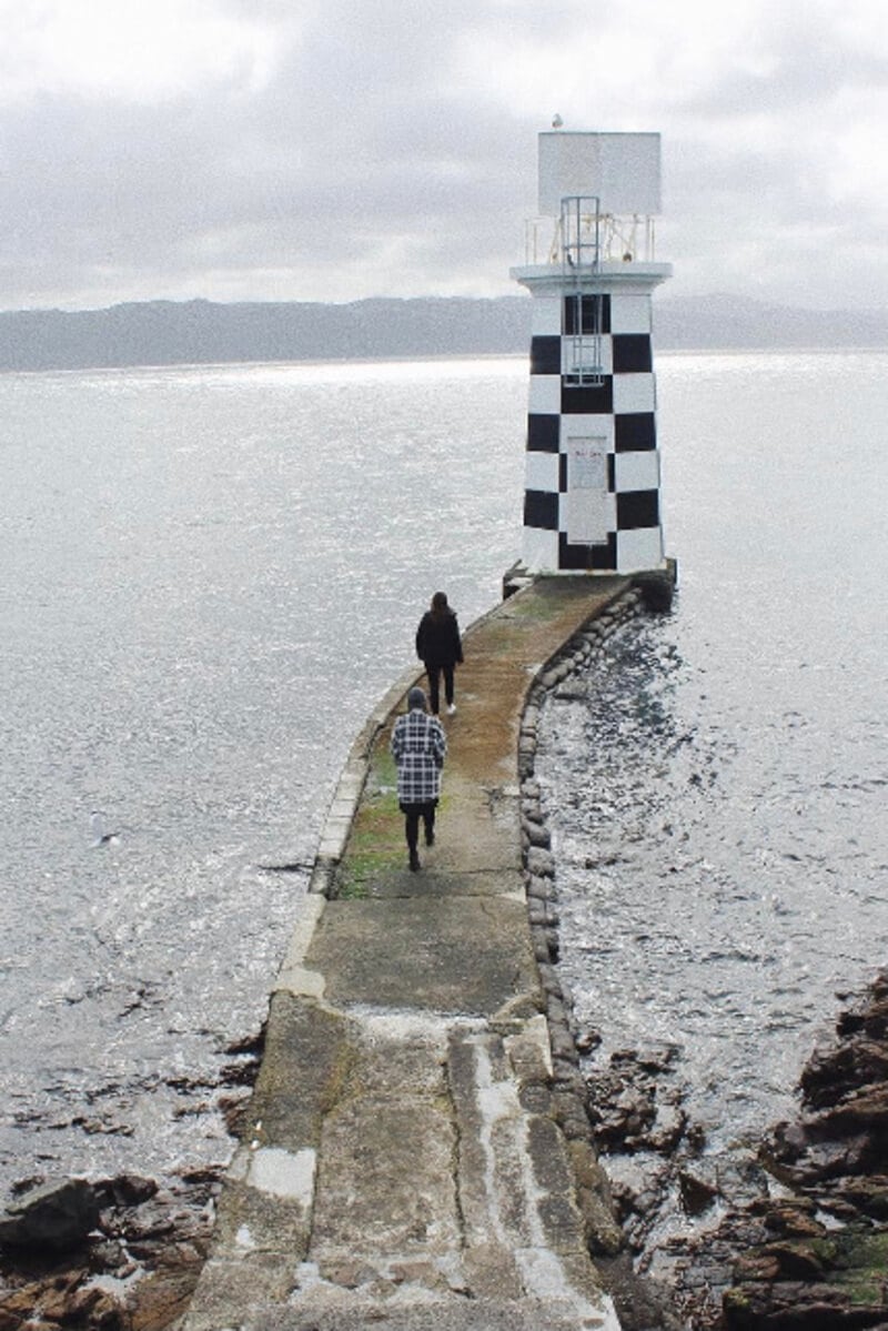 Two girls walking towards Point Halswell Lighthouse