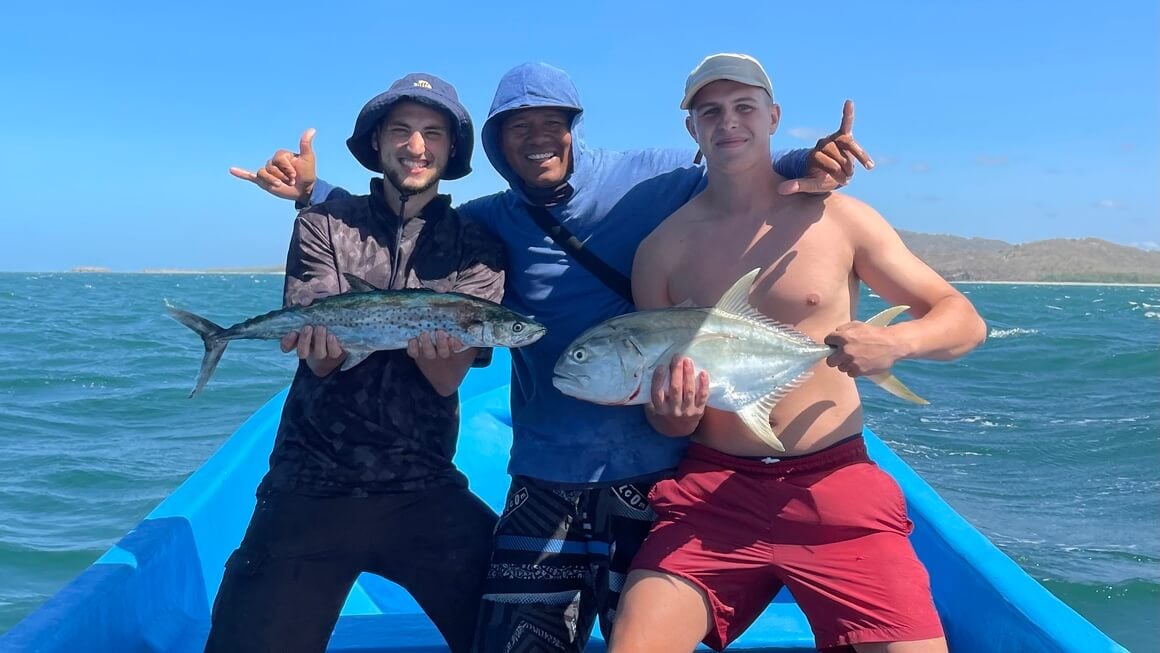 three men with fish out at sea