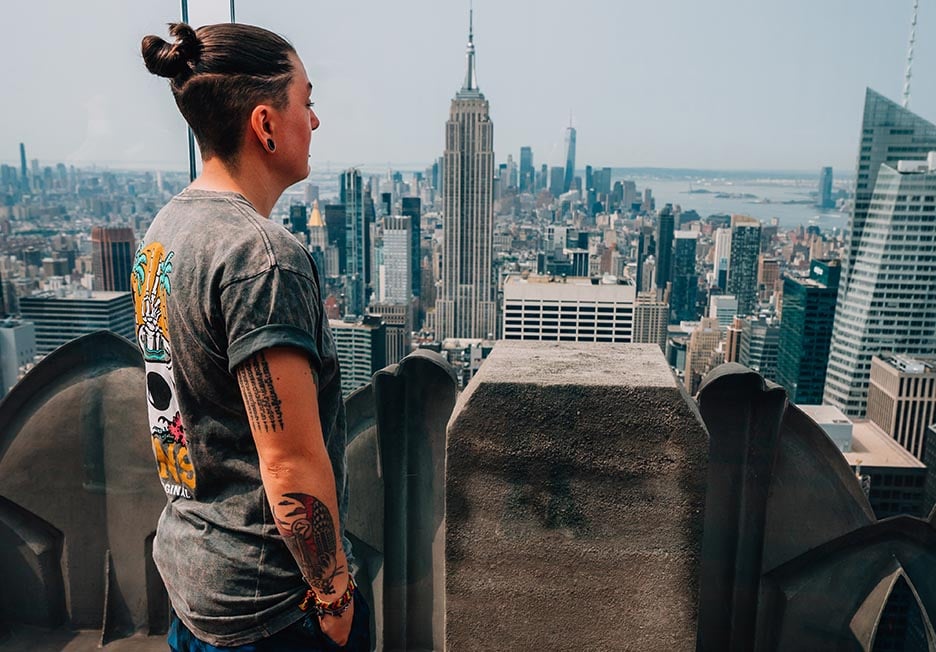 A person looking out over NYC and The Empire State Building