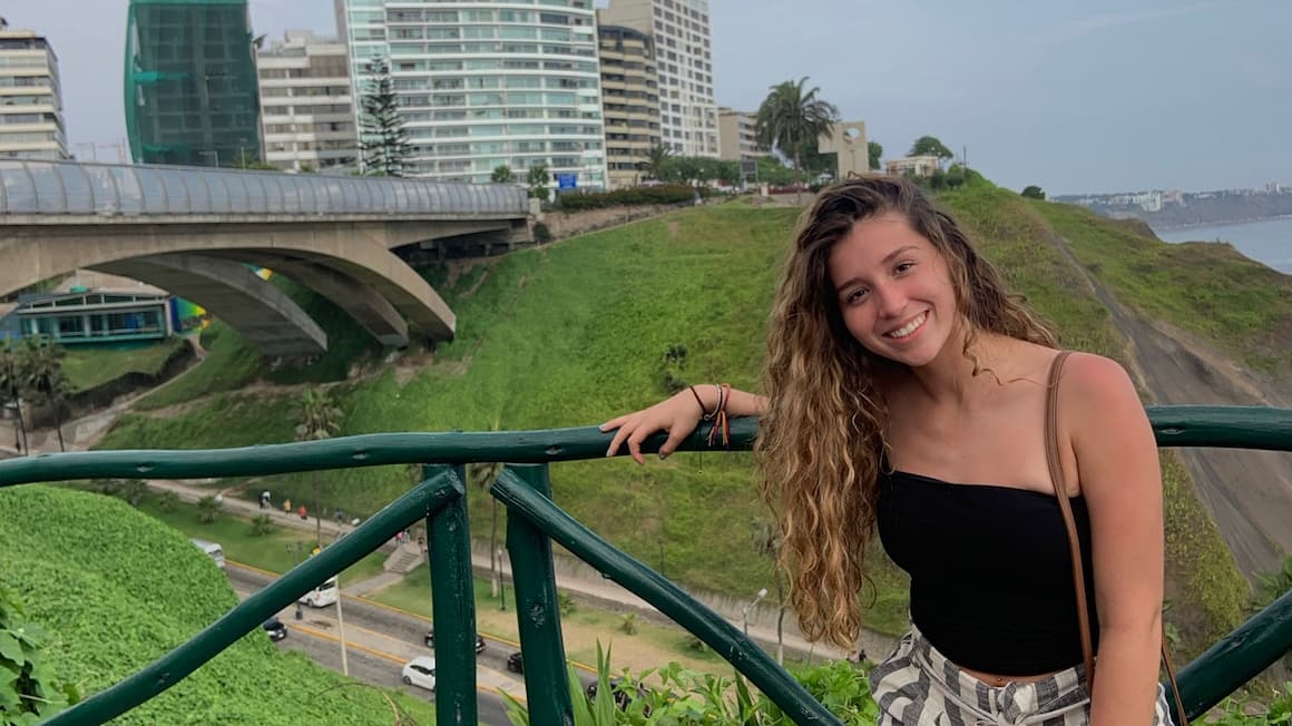 a girl in lima, peru with skyscrapers in the background 
