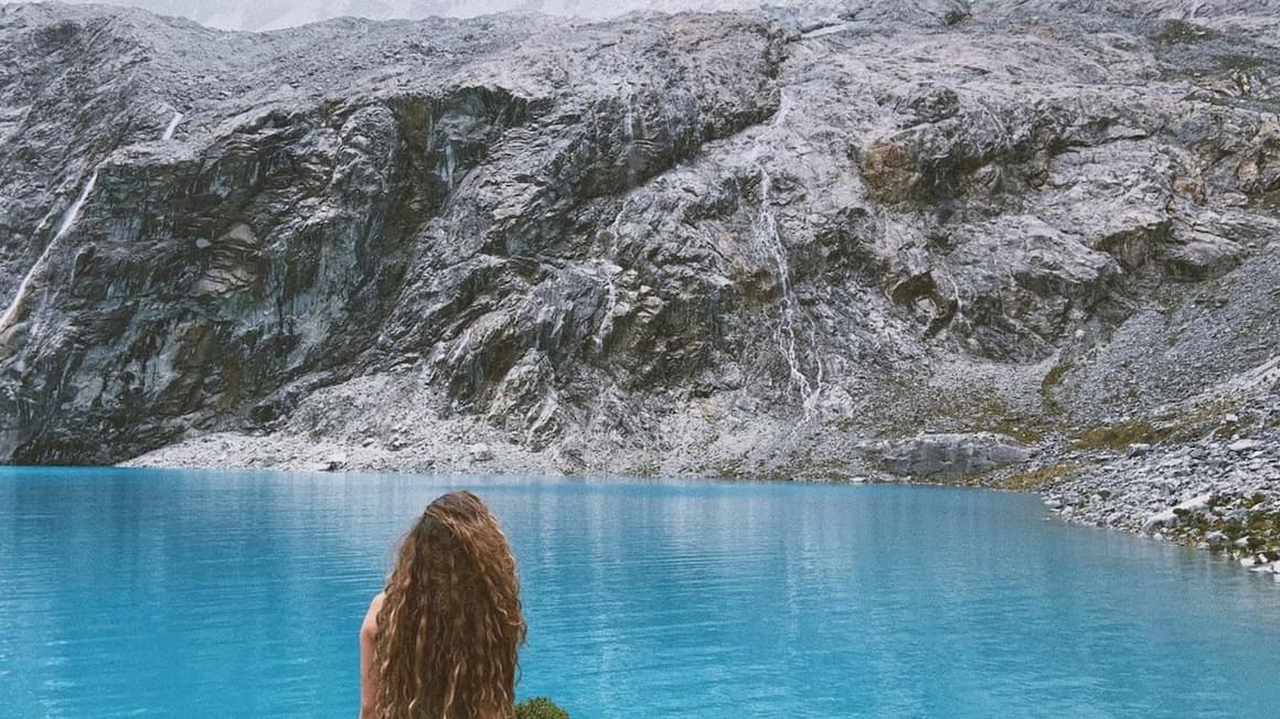 a girl exploring a lake in the mountains of Peru