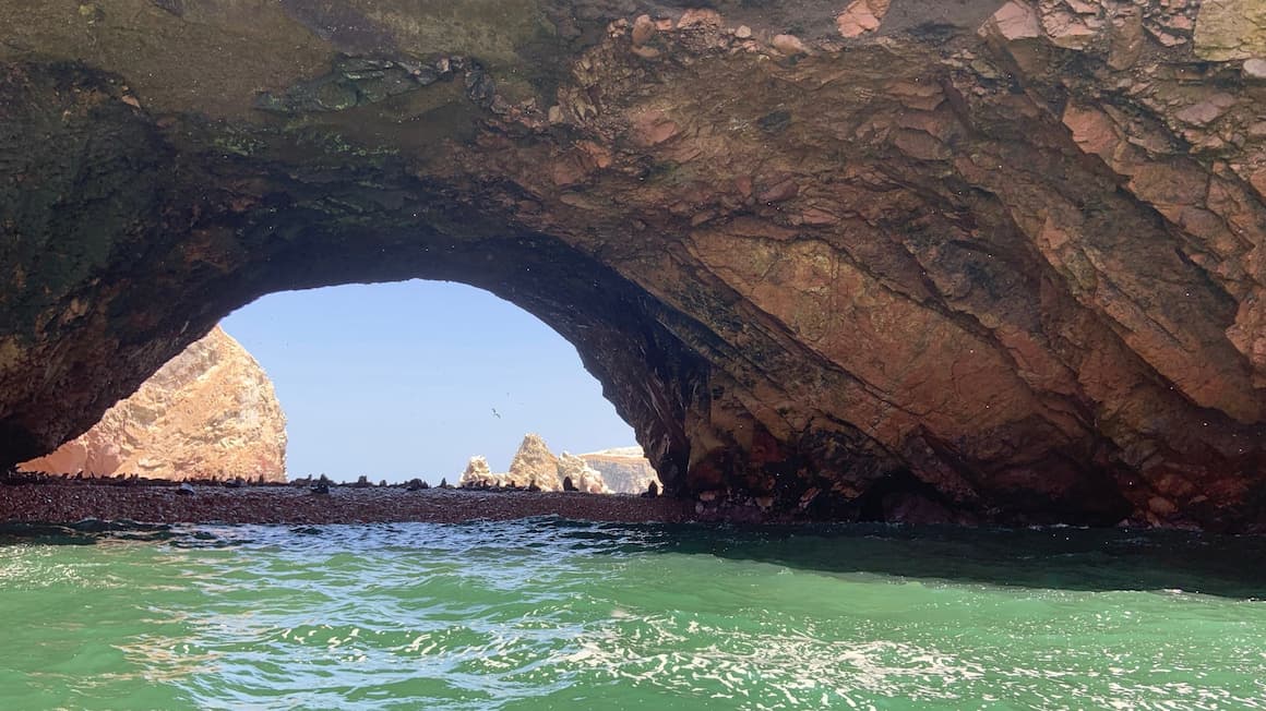 a large cave in peru with seals in the distance