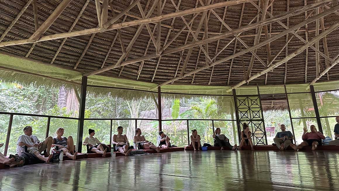 Group sat relaxed in an arch under wooden roof 