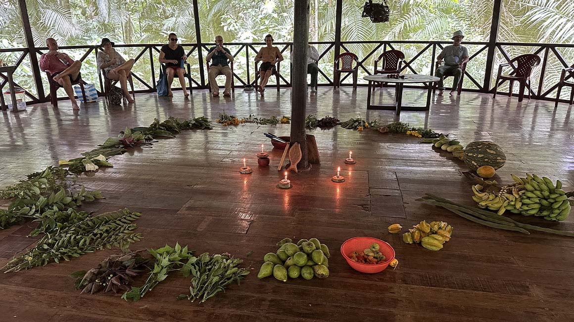 circle of food with candles in the centre and people in a circle at the edge of the structure 