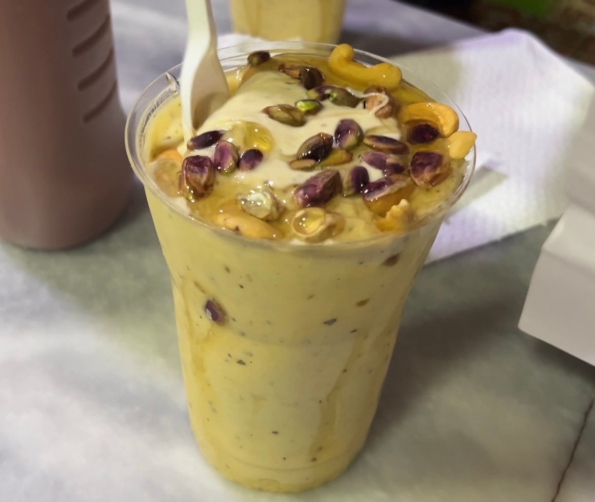bright yellow smoothie topped with nuts and honey in afghanistan