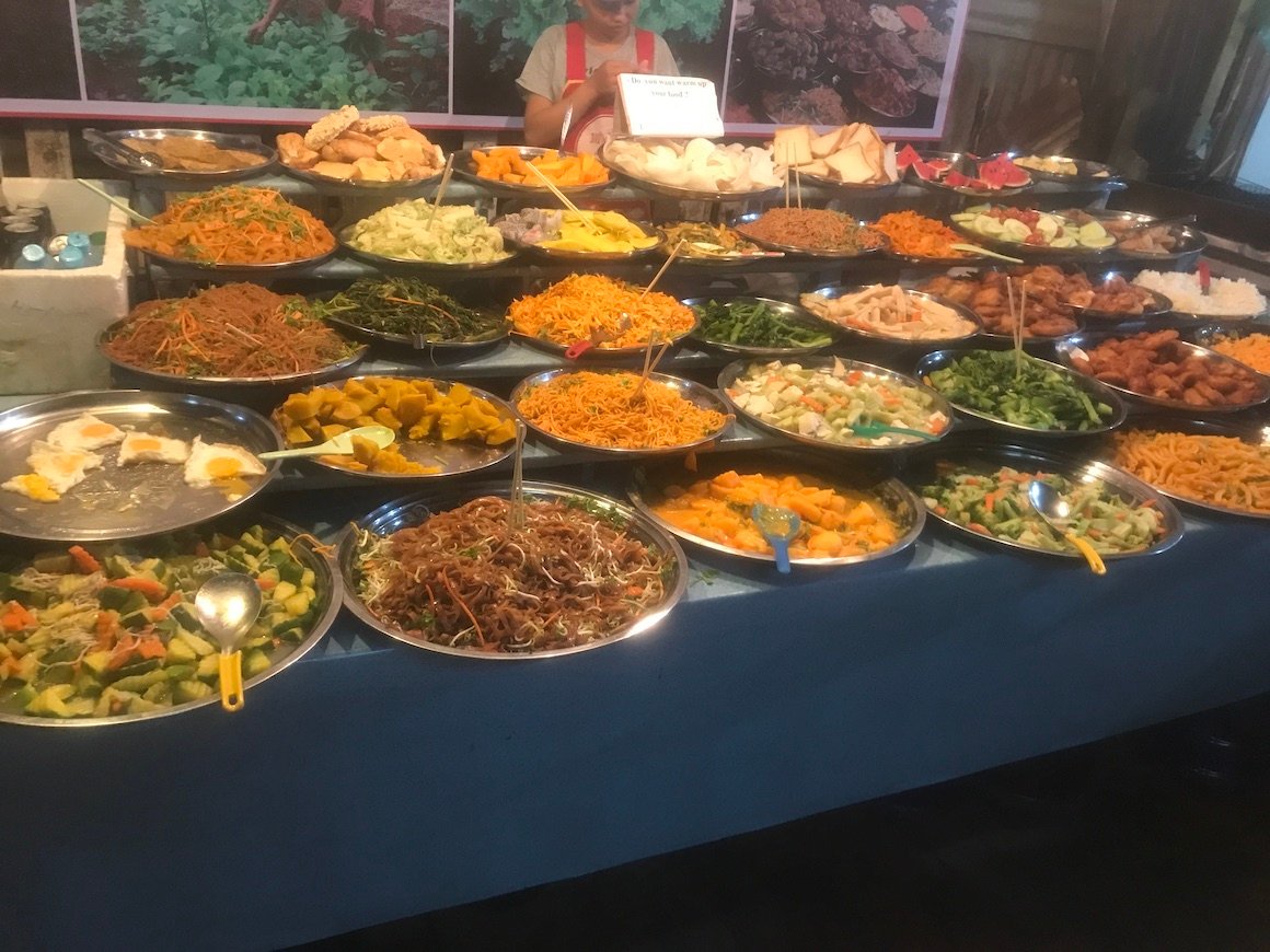 various plates of food on display at a street food night market in luang prabang laos