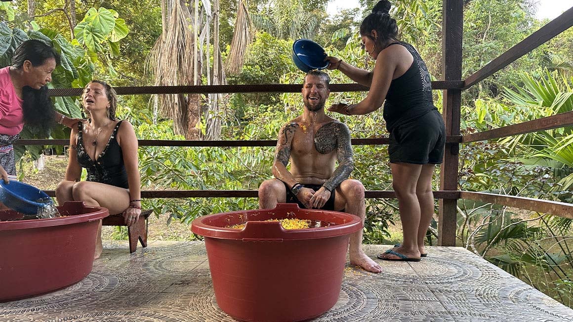 Travelers having a flower bath in ayahuasca retreat.
