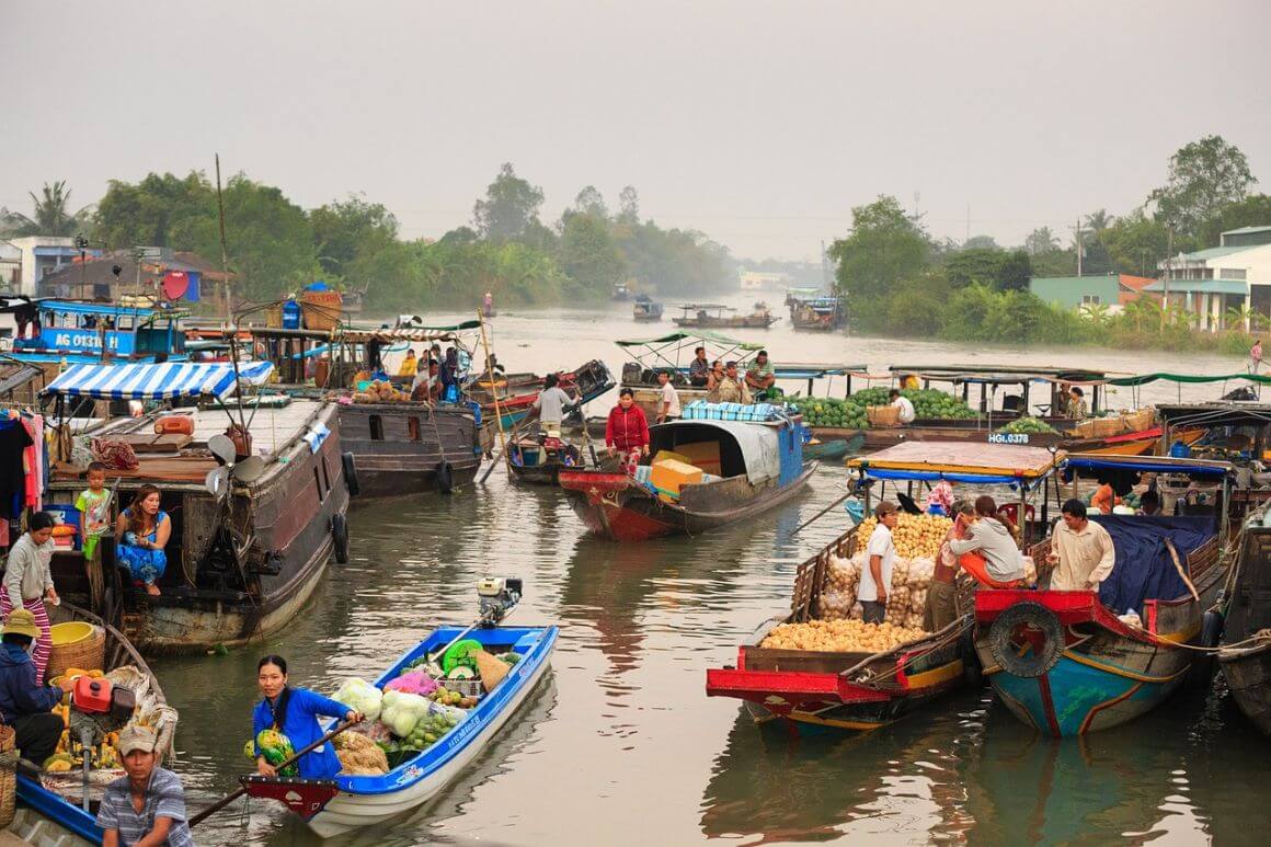 Locals navigating Mekong River in the Mekong Delta on their sampans