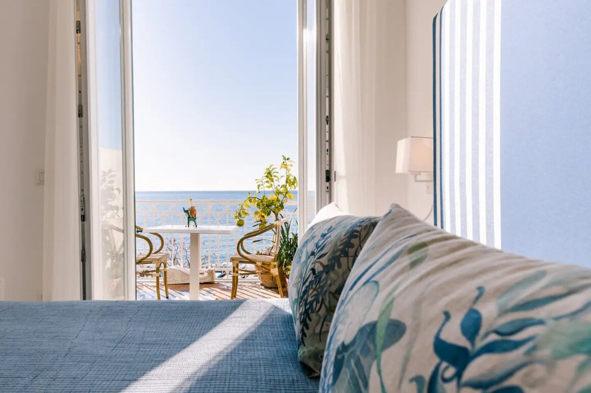 View of the blue bed linen and out to the stunning terrace looking over the sea