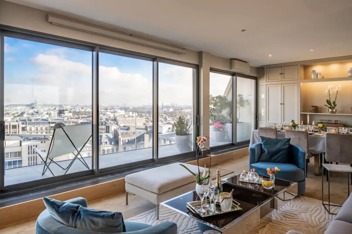 View from the living area in a modern apartment. Large floor to ceiling windows with small terrace over looking the city.